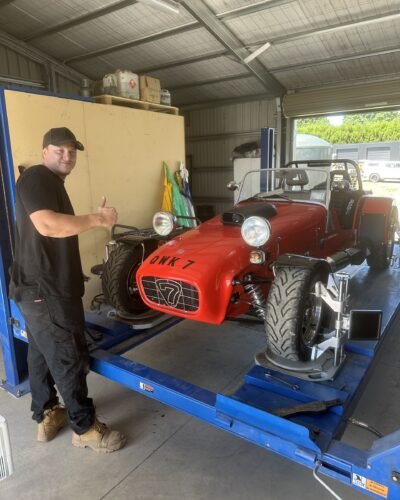 George Mcloed, co-owner of Tyre Save Direct, beside a Caterham Seven on the wheel alignment rack in Kerikeri